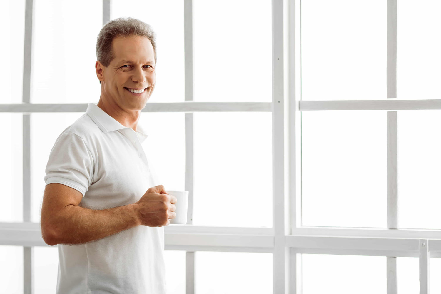 Handsome middle aged man smiling and holding a cup of coffee, ready for a date after using KeraFiber hair building fibers.